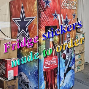 Puede incluir: Un refrigerador de dos puertas cubierto con un vinilo personalizado que muestra el logo de la estrella de los Dallas Cowboys, un jugador de f&uacute;tbol americano con uniforme plateado y azul, una botella de Coca-Cola y un casco sobre un fondo de estrellas.
