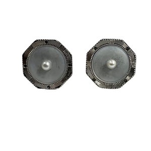 Puede incluir: Un par de gemelos de plata con un centro de perla blanca y un diseño octogonal decorativo.