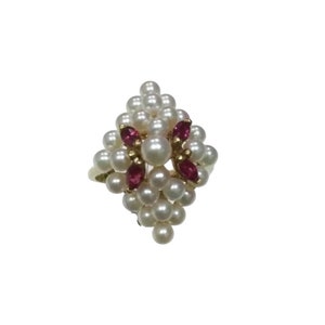 May include: A gold ring with a cluster of white pearls and red gemstones.