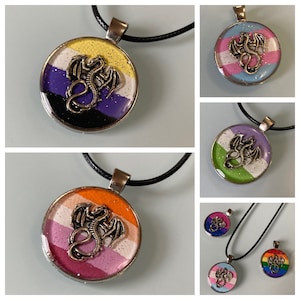 May include: A set of necklaces with round pendants featuring different pride flags and a silver dragon design. The flags include the transgender, lesbian, bisexual, and pansexual flags.