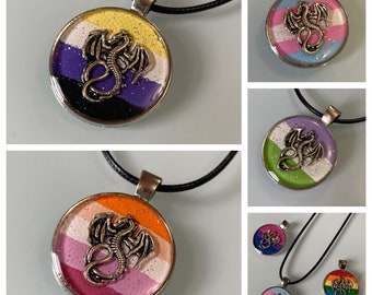 May include: A set of necklaces with round pendants featuring different pride flags and a silver dragon design. The flags include the transgender, lesbian, bisexual, and pansexual flags.