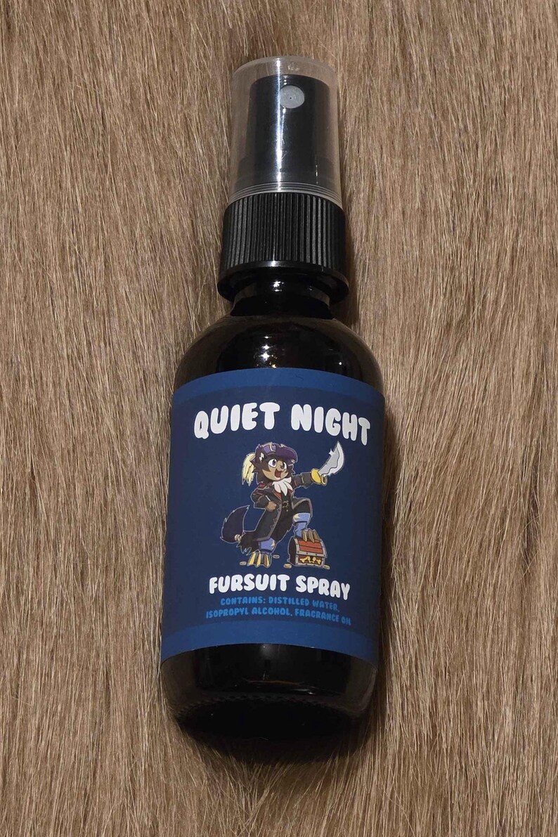 May include: A dark glass spray bottle with a black cap, labeled "Quiet Night Fursuit Spray." The label features a cartoon character and the text "Fursuit Spray." The bottle contains distilled water, isopropyl alcohol, and fragrance oil.