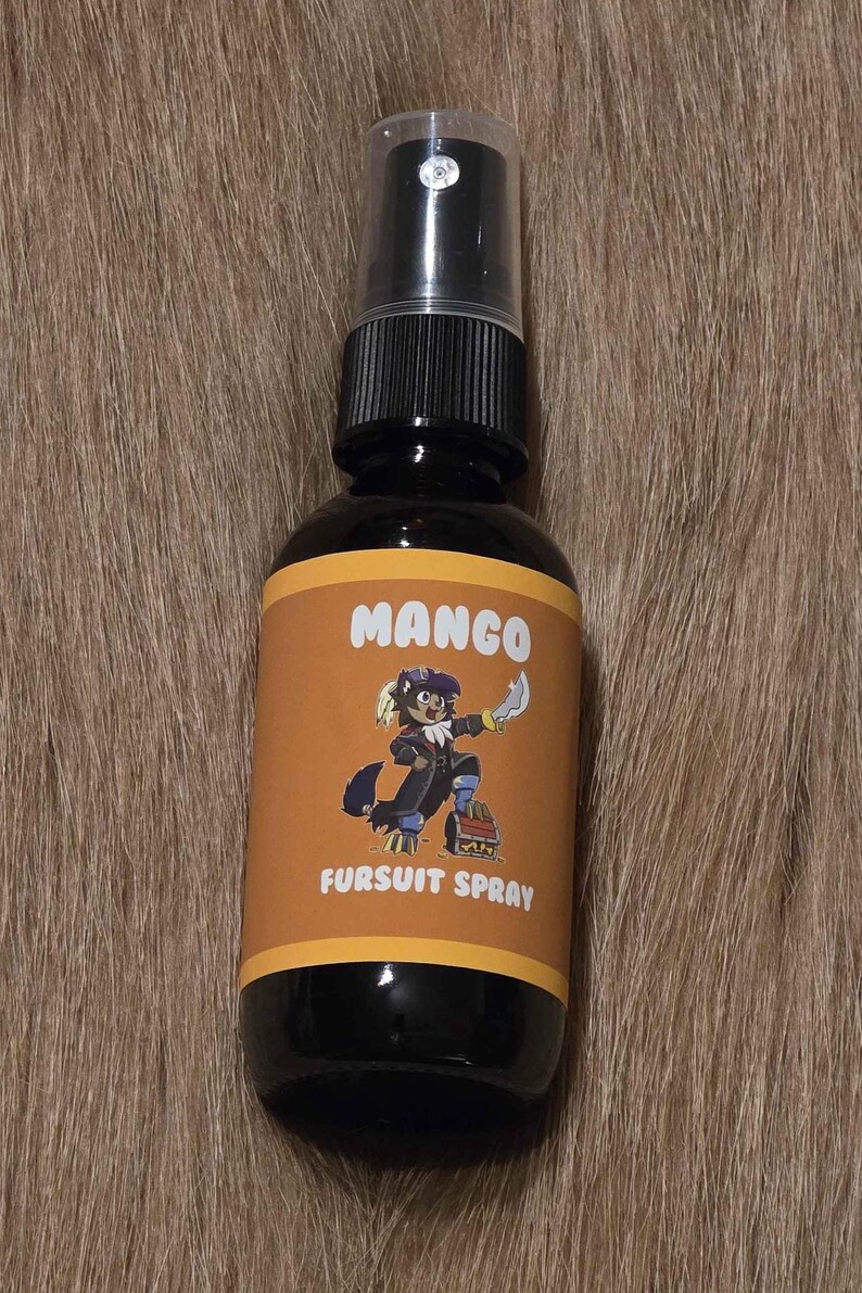 May include: A dark brown spray bottle with a black pump and a label that reads "MANGO FURSUIT SPRAY." The label features a cartoon character with a knife. The bottle is set against a brown, textured background.
