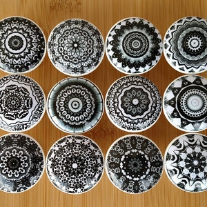May include: Twelve black and white ceramic knobs with intricate mandala designs. The knobs are round and have a glossy finish.