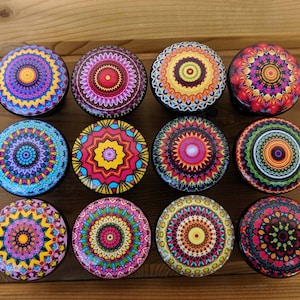 May include: Twelve round, colorful, decorative knobs with intricate mandala designs. Each knob features a different color scheme and pattern, including shades of blue, red, yellow, green, and purple.