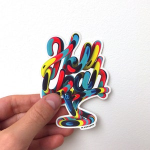 Puede incluir: Una pegatina colorida con la palabra "Hello" escrita en estilo 3D con un esquema de color azul, amarillo, rojo y negro. La pegatina tiene un fondo blanco y la firma del artista "M. URTASUN" está impresa en la esquina inferior derecha.