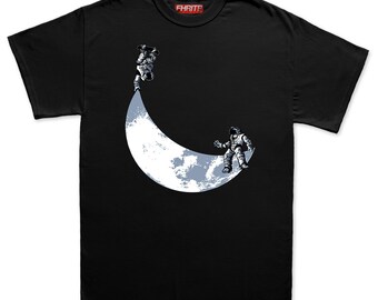 Puede incluir: Camiseta negra con un gráfico de dos astronautas en una luna creciente. Un astronauta está boca abajo y el otro de pie. La luna es blanca y azul claro. El texto "FHRITP" está en la parte superior.