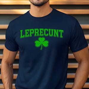 A man wearing a navy blue t-shirt with the text "Leprecht" and a green shamrock graphic printed on it.