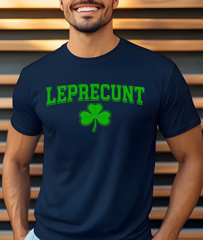 A man wearing a navy blue t-shirt with the text "Leprecht" and a green shamrock graphic printed on it.