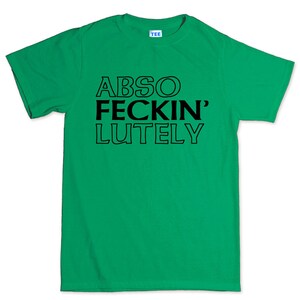 May include: A bright green t-shirt with the words "ABSO FECKIN' LUTELY" printed in bold black letters. The shirt has a crew neck and short sleeves. The word "TEE" is printed on the tag.