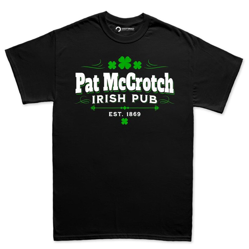 A black t-shirt with white text and green shamrocks printed on it.