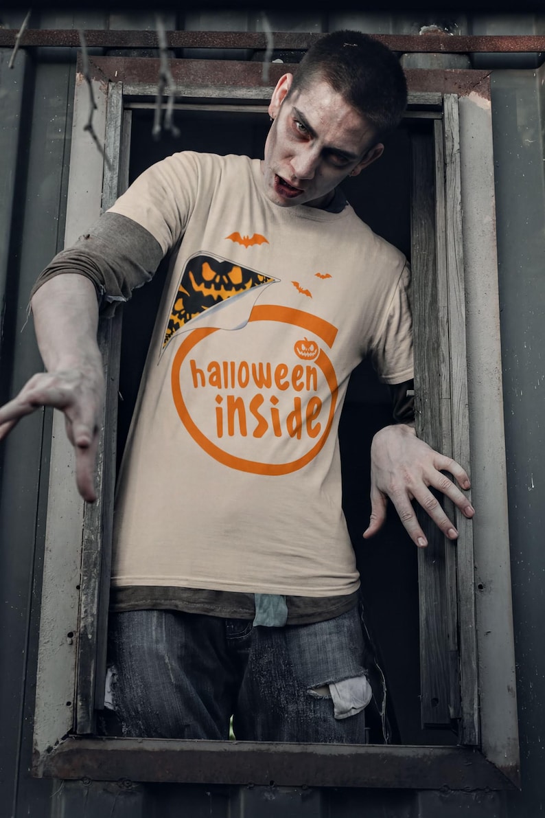 A man wearing a Halloween-themed t-shirt with the text "Halloween inside" is peeking out from behind a window frame.