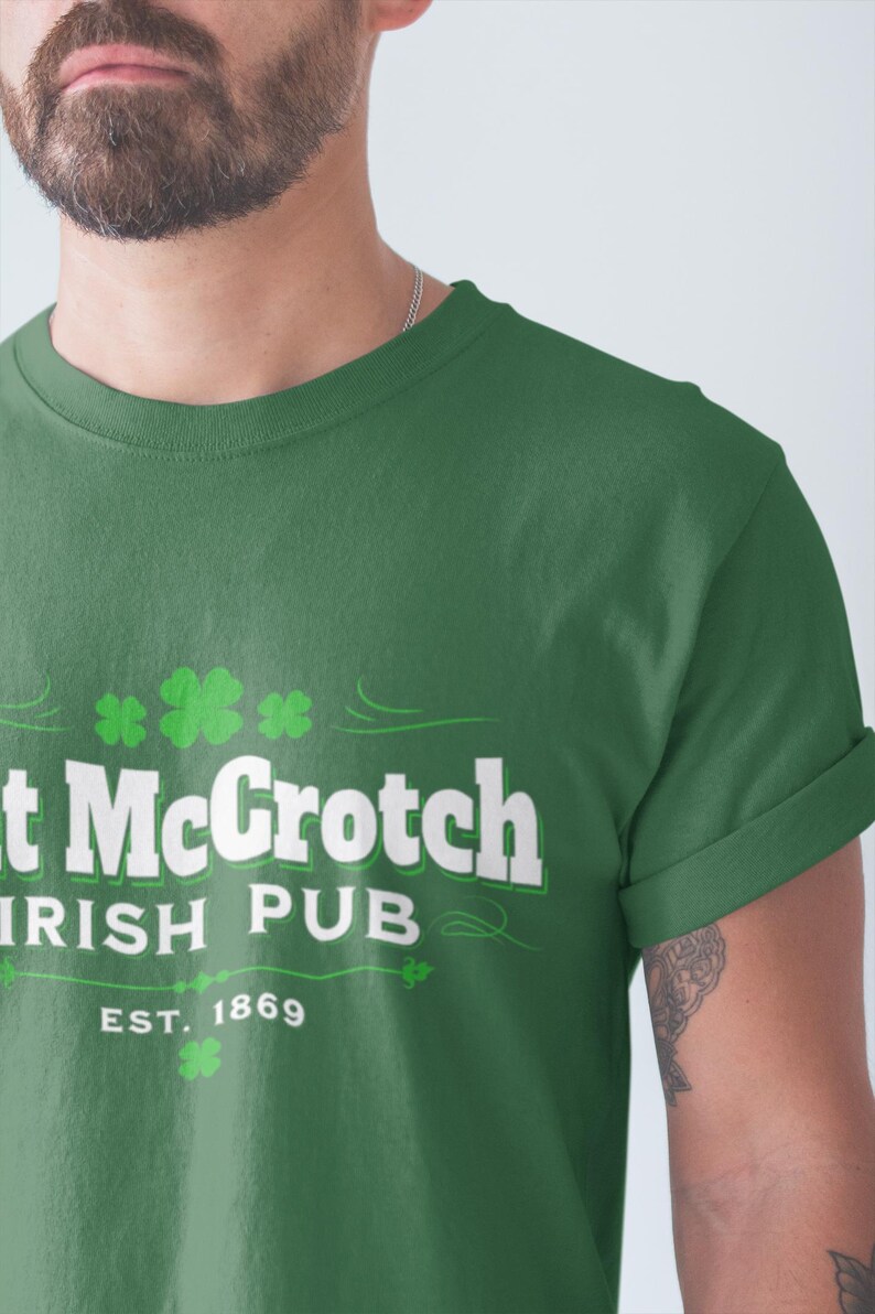 A man wearing a green t-shirt with white text and a shamrock design.