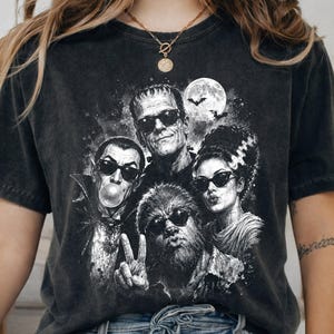 A black t-shirt with a graphic design featuring the characters from the horror movie "The Bride of Frankenstein".