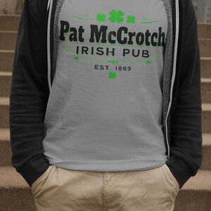 A person wearing a gray t-shirt with the text "Pat McCroch Irish Pub EST. 1869" printed on it, standing on a set of stairs.