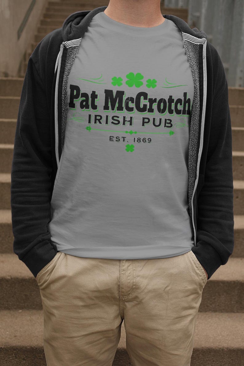 A person wearing a gray t-shirt with the text "Pat McCroch Irish Pub EST. 1869" printed on it, standing on a set of stairs.