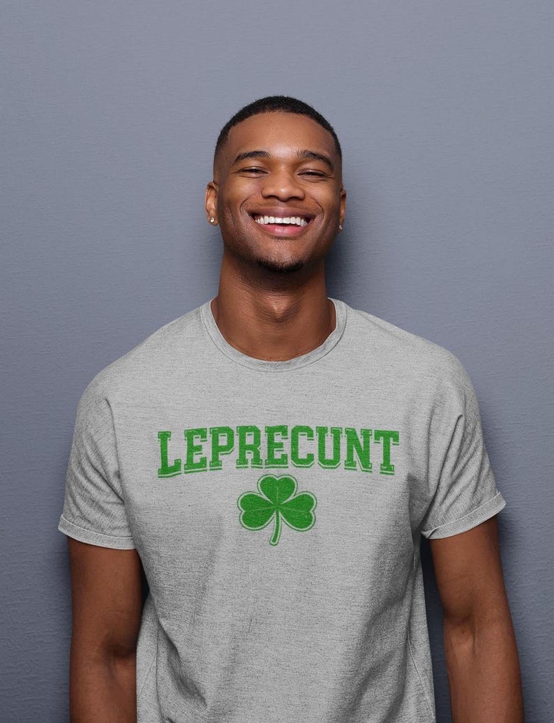 A smiling man wearing a grey t-shirt with the word "Leprecht" printed on it.