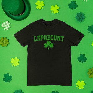 a black t-shirt with the word "Leprecht" printed on it, surrounded by various Leprecht-themed items such as shamrocks, hats, and other accessories.