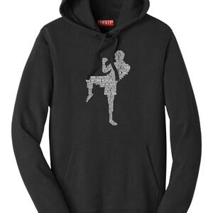 Puede incluir: Sudadera con capucha negra con un gráfico blanco de un artista marcial en posición de patada. El gráfico está compuesto por nombres. El nombre de la marca "FHRITP" está impreso en la capucha.