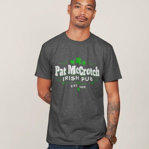 A man wearing a grey t-shirt with the text "Pat McCroch Irish Pub EST 1869" printed on it.