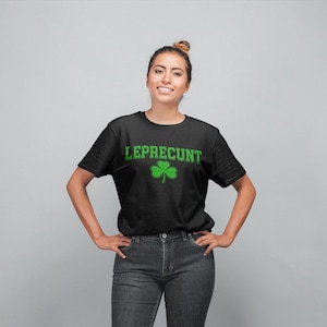 A woman wearing a black t-shirt with the text "LEPRECIUT" and a shamrock graphic, smiling at the camera.