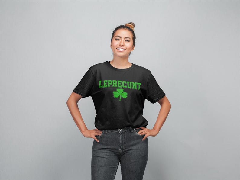 A woman wearing a black t-shirt with the text "LEPRECIUT" and a shamrock graphic, smiling at the camera.