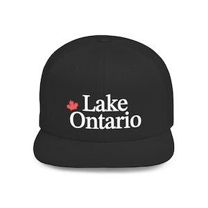 May include: A black baseball cap featuring the white embroidered text Lake Ontario on the front panel. To the left of the text is a small, red embroidered maple leaf icon. The cap has a structured crown and a flat brim, presenting a clean design.