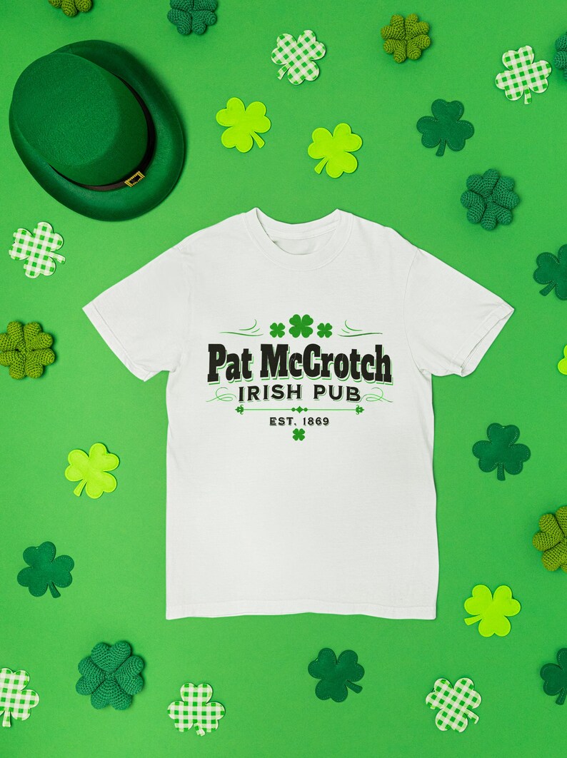a white t-shirt with the text "Pat McGroch Irish Pub EST. 1969" printed on it, along with a green hat and various shamrocks scattered around the t-shirt.