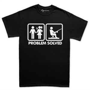 May include: A black short-sleeved t-shirt featuring a white graphic print. The design displays two square icons: one showing a person speaking to another, and the second showing a person fishing. The text "PROBLEM SOLVED" is printed in white below.