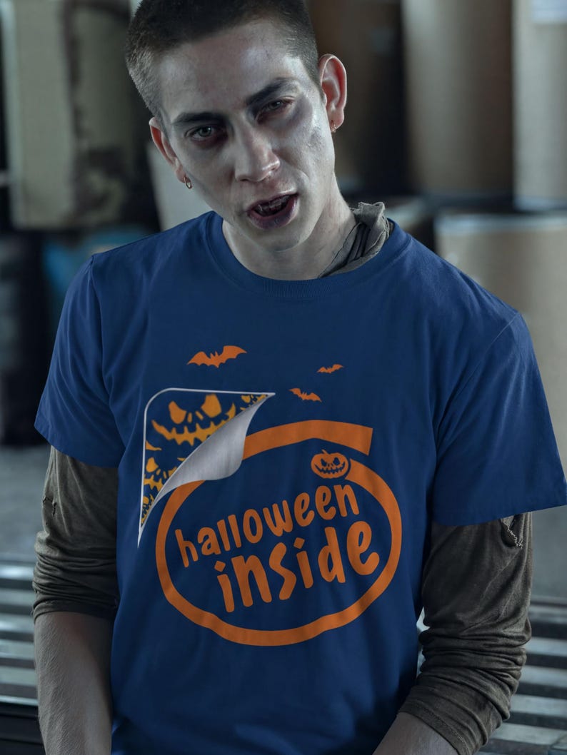 A man wearing a blue t-shirt with the text "Halloween inside" printed on it, looking directly at the camera with a serious expression.