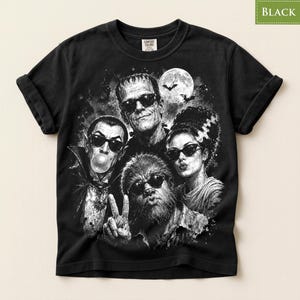 A black and white t-shirt with a graphic design featuring the faces of the characters from the horror movie "The Bride of Frankenstein".