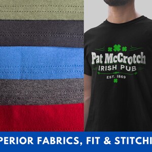 A black t-shirt with the text "Pat McCroch Irish Pub EST. 1869" printed on it, along with a green shamrock symbol. The t-shirt is displayed next to a pile of various colored fabrics, suggesting a selection of materials for clothing or textile purposes.