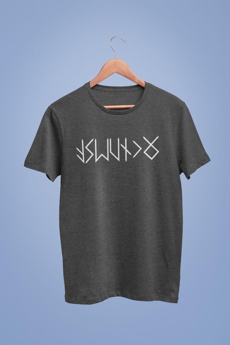 A gray t-shirt with white text printed on it, hanging on a wooden hanger against a blue background.