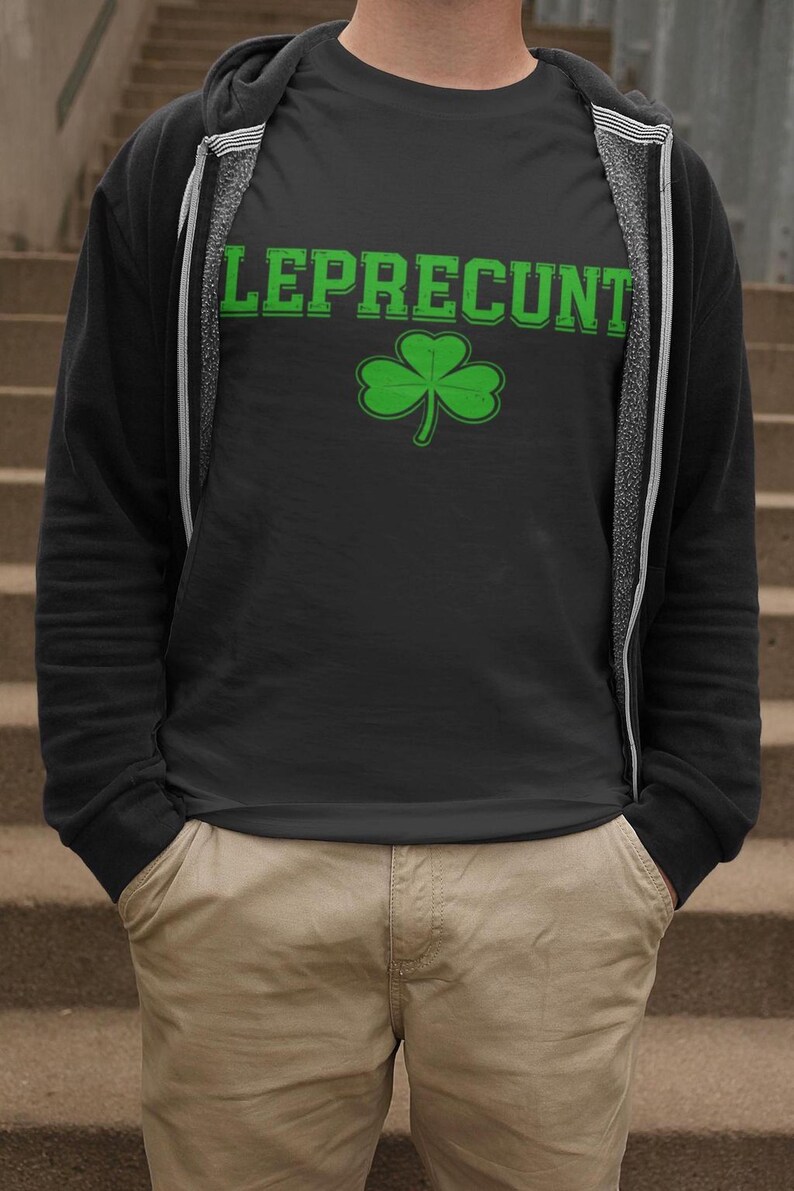 A person wearing a black t-shirt with the text "LEPRECIUNT" and a green shamrock graphic, standing on a set of stairs.