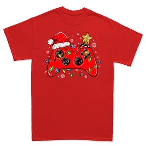 K&ouml;nnte beinhalten: Rotes T-Shirt mit einem Weihnachts-Videospiel-Controller-Design. Der Controller ist mit einem Weihnachtsmann-Hut, Weihnachtslichtern und einem Stern obenauf verziert.