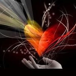 May include: A red and yellow heart with a white outline, surrounded by white lines and sparkles, is held in a hand against a black background.
