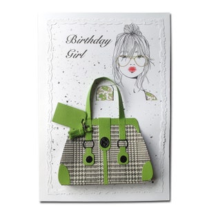 Op de afbeelding: Een groen-wit gepatroneerde handtas met een groen label en kwast. De kaart heeft de tekst "Birthday Girl".
