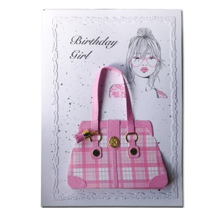 Op de afbeelding: Een roze en witte geruite handtas met een gouden sluiting en kwast. De kaart zegt "Birthday Girl".