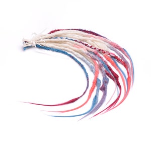 Puede incluir: Un conjunto de rastas sintéticas en tonos de blanco, rosa, azul y rojo. Las rastas están atadas juntas en la parte superior con una cinta blanca.