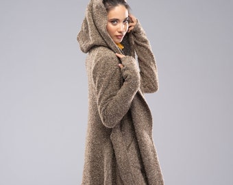 May include: A brown hooded cardigan with a long, asymmetrical hem. The cardigan is made of a soft, fuzzy material and has a relaxed fit.