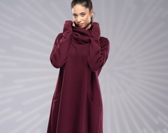 May include: A long, burgundy-colored dress with a cowl neck and side slits. The dress is made of a soft, comfortable fabric and has a relaxed fit.
