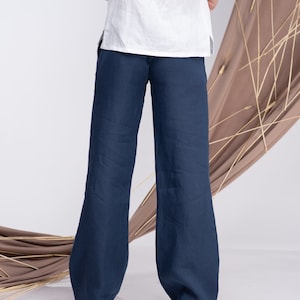 May include: A pair of wide-leg, dark blue linen trousers. The trousers have a relaxed fit and a straight leg.