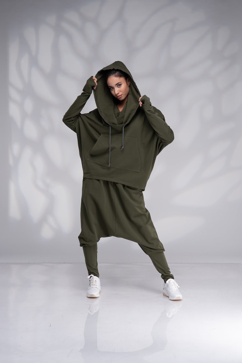 K&ouml;nnte beinhalten: Ein gr&uuml;ner Kapuzenpullover und eine passende Hose mit Kordelzug. Das Outfit ist aus einem weichen, bequemen Stoff.