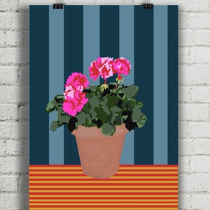 May include: A potted pink geranium plant with green leaves sits on a table with red and yellow stripes. The background is a blue and grey striped wall.
