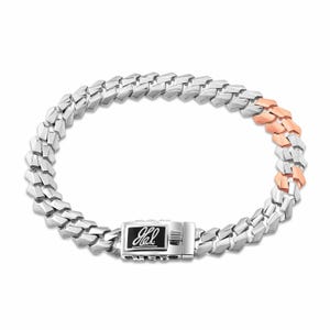 May include: A silver and rose gold chain bracelet with a clasp that has the inscription "J. Hal" on it.