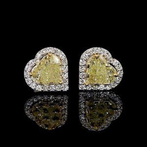 Könnte beinhalten: Ein Paar herzförmige Diamant-Ohrringe mit einem gelben Mittelstück, das von kleineren weißen Diamanten umgeben ist.