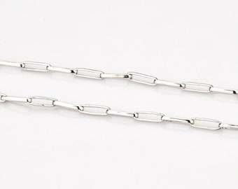 May include: A silver chain necklace with a delicate, linked design. The chain is made of small, rectangular links.