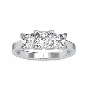 May include: A silver ring with three square-shaped diamonds set in a row.