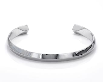 May include: A polished silver-tone metal cuff bracelet featuring a continuous twisted design that creates a series of angled, reflective surfaces along the band. The bracelet has an open back construction with tapered ends and a smooth, metallic finish.