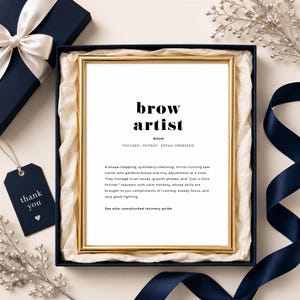 Pode incluir: Uma impressão com moldura dourada apresentando a definição estilo dicionário de um brow artist. O texto diz: brow artist, noun, focused, patient, detail-obsessed. Inclui um parágrafo descritivo sobre o design de sobrancelhas.